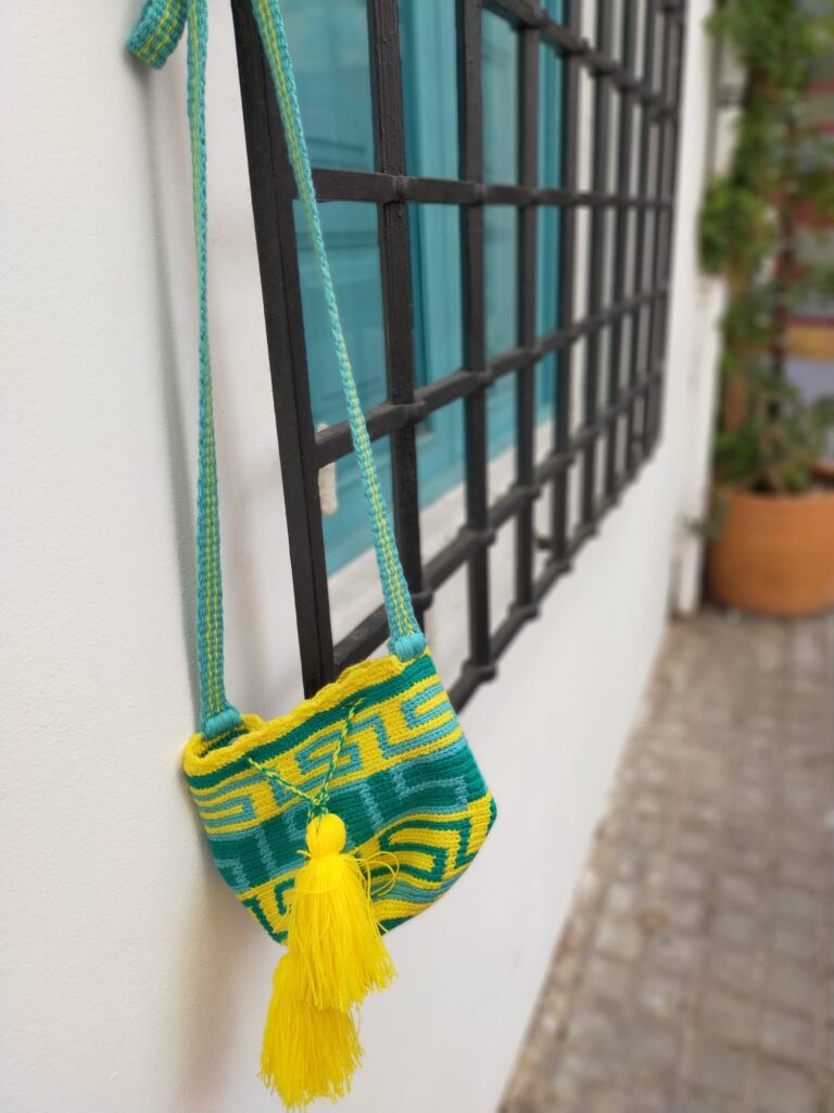 Mochila wayuú hecha por las indígenas wayuú de Colombia, color amarilla, verde y azul celeste